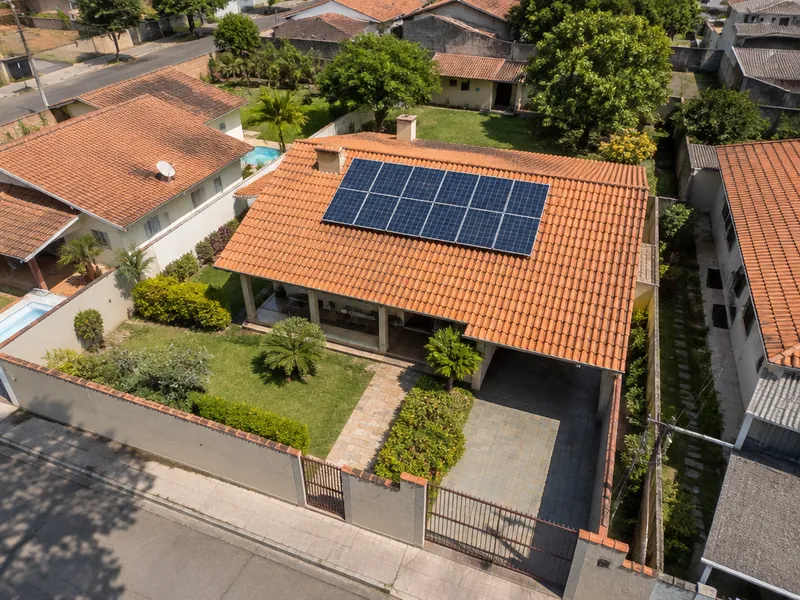Casa com painéis solares no telhado, vista de cima